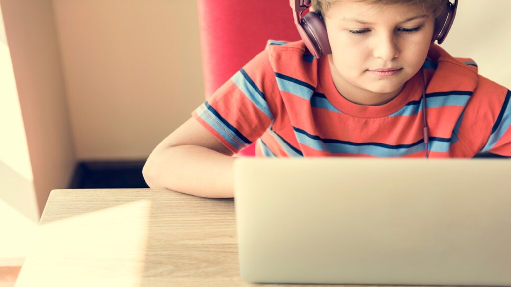 Kid Boy Headphone Using Laptop Concept