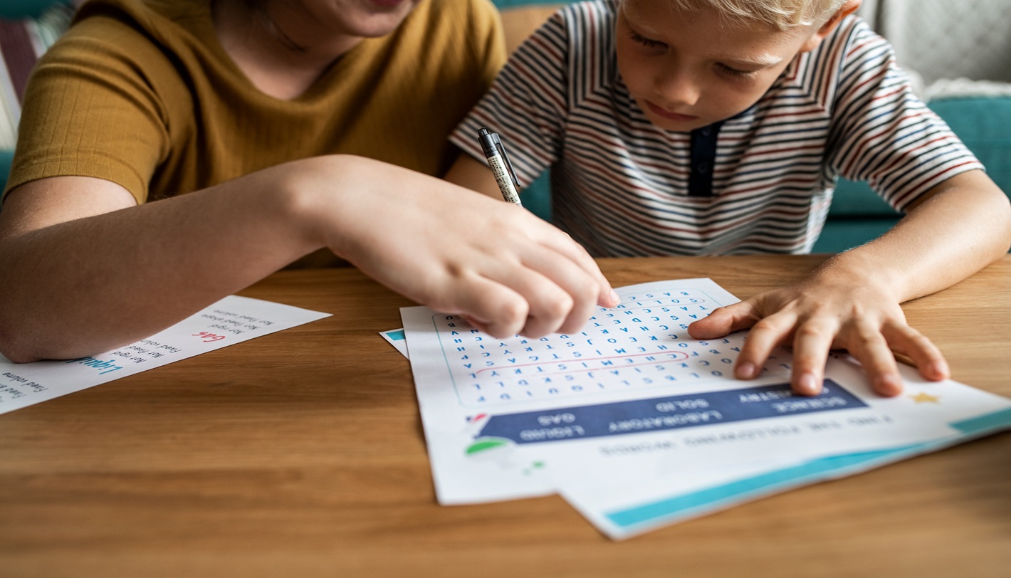 Sister playing word search with her little brother