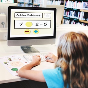 A young girl doing a maths test on the computer