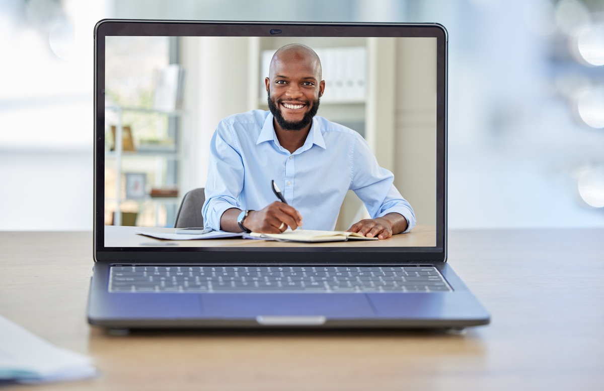 A man in a laptop on a conference call with the scenario of a tutor teaching a student.