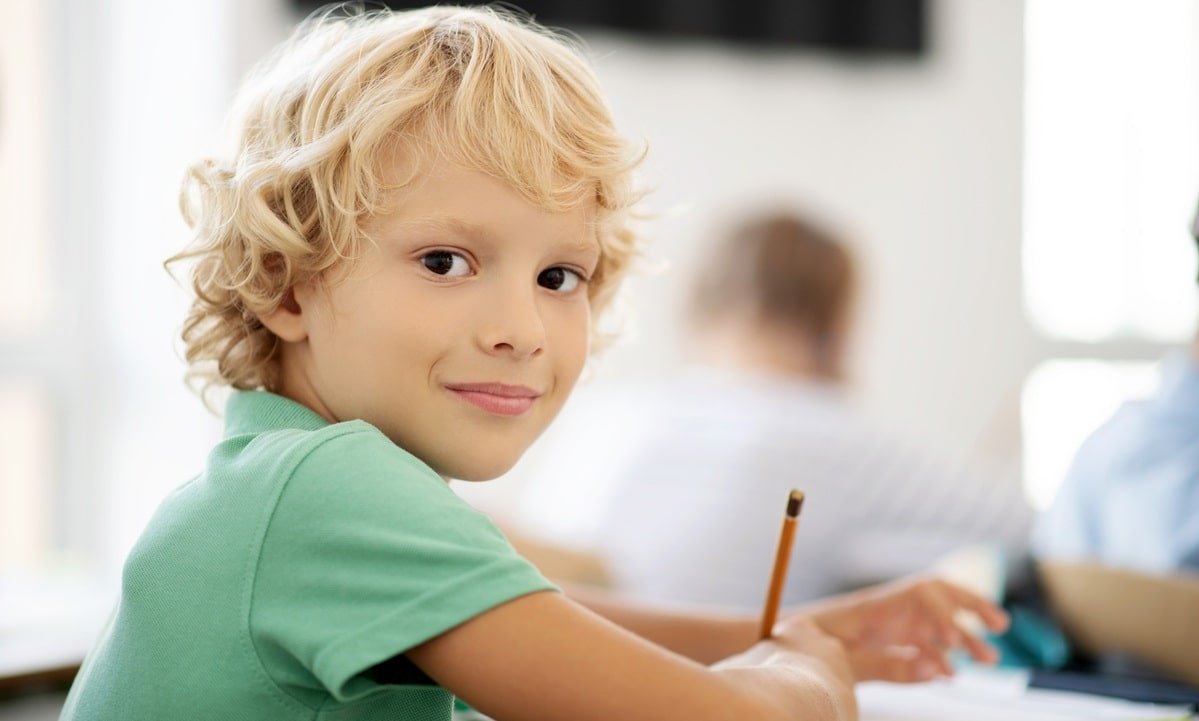 A young boy showing confidence in a classroom after an online session with ATTC Education.